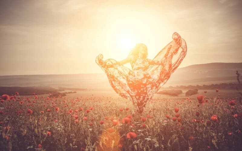 Nữ người mẫu với váy lụa bay bồng bềnh dưới ánh mặt trời lấp lánh.